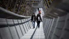 Orang-orang berjalan melewati Jembatan 516 Arouca di Arouca, Portugal (29/4/2021). Jembatan 516 Arouca merupakan jembatan gantung terpanjang di dunia yang membentang sejauh 516 meter di ketinggian 175 meter. (AFP/Carlos Costa)