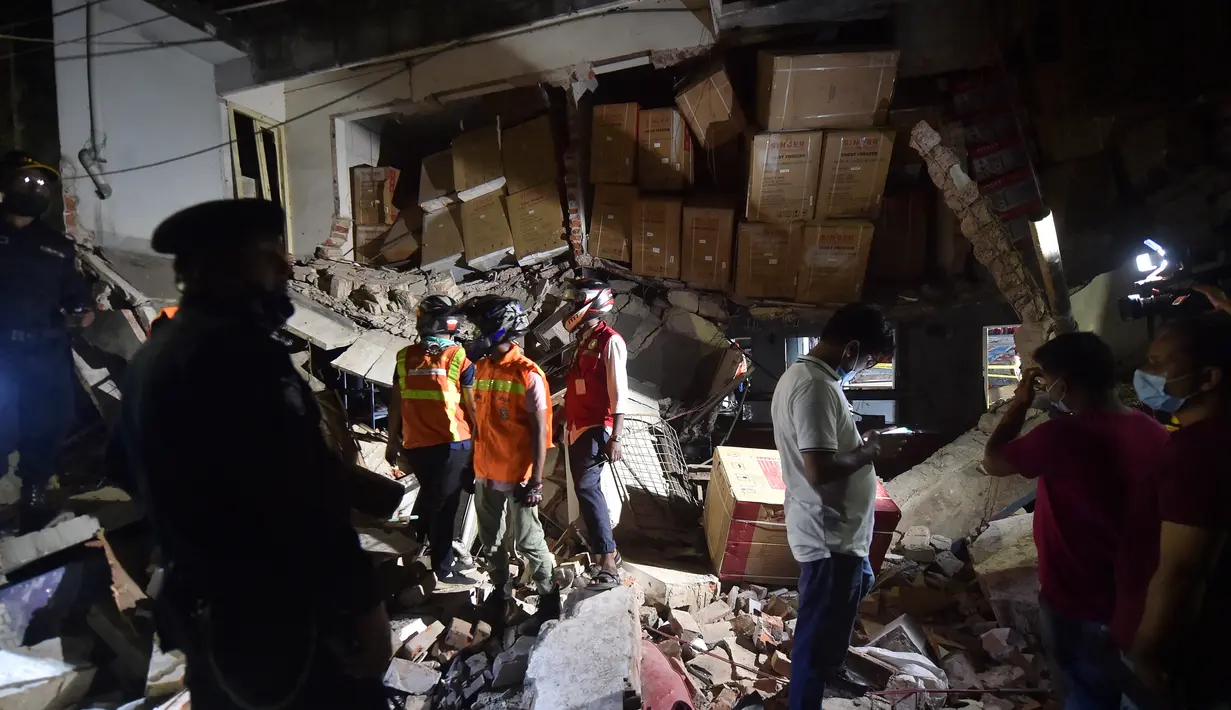 Petugas pemdam kebakaran memeriksa tempat kejadian setelah dugaan ledakan gas di jalanan ramai di Moghbazar, Dhaka, Bangladesh, Minggu (27/6/2021). Tayangan televisi memperlihatkan pilar-pilar yang rubuh, beton pecah dan pecahan kaca berserakan di seberang jalan. (Munir Uz zaman/AFP)
