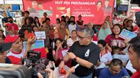 Sekretaris Jenderal (Sekjen) DPP PDIP Hasto Kristiyanto membagikan telur ke warga di kawasan Rumah Susun Tanah Tinggi, Senen, Jakarta Pusat. (Liputan6.com/Nanda Perdana Putra)