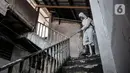 Petugas Palang Merah Indonesia (PMI) Jakarta Timur berpakaian APD menyemprotkan disinfektan di permukiman Kampung Tengah, Kramat Jati, Minggu (23/8/2020). Penyemprotan sebagai langkah sterilisasi permukiman setelah warga di Kampung Tengah dilaporkan terpapar Covid-19. (Liputan6.com/Iqbal Nugroho)