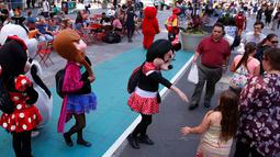 Karakter Disney Minnie Mouse menawarkan pengunjung untuk berfoto bersama di Times Square, New York, Selasa (21/6). Di sini banyak terdapat beraneka macam pengamen jalanan untuk menghibur pengunjung. (REUTERS/Lucas Jackson)