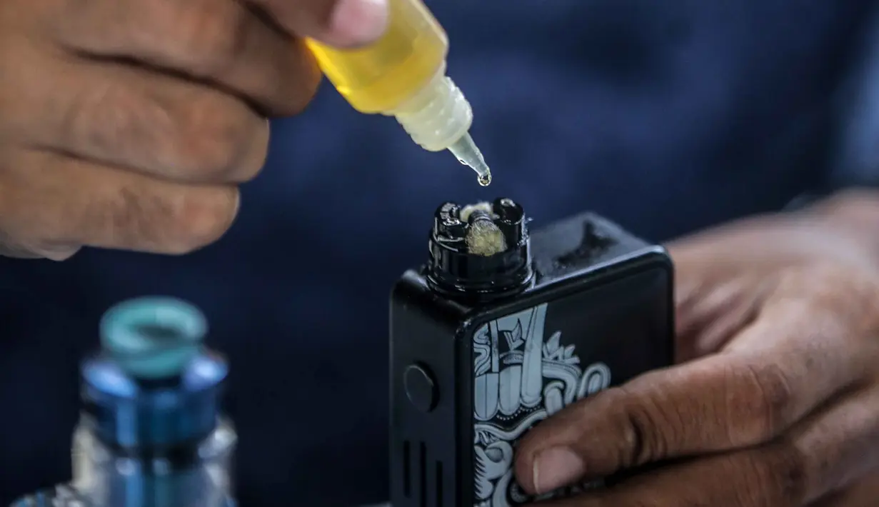 Seorang pria meneteskan cairan vape atau rokok elektronik di kawasan Bundaran HI, Jakarta, Selasa (12/11/2019). Pemerintah melalui BPOM mengusulkan pelarangan penggunaan rokok elektrik dan vape di Indonesia, salah satu usulannya melalui revisi PP Nomor 109 Tahun 2012. (Liputan6.com/Faizal Fanani)