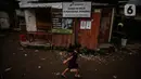 Seorang anak bermain di antara reruntuhan rumah di kawasan permukiman Jalan Pancoran Buntu II, Pancoran, Jakarta, Selasa (30/3/2021). Anak-anak yang tidak tahu permasalahan atas sengketa tanah menjadi korban dan terpaksa bermain di sisa reruntuhan tempat tinggal mereka. (Liputan6.com/Johan Tallo)