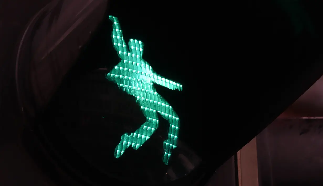Sebuah lampu lalu lintas bergambar siluet Elvis Presley tengah berdansa di Friedberg, Jerman pada 7 Desember 2018. Lampu hijau Elvis memperlihatkan gerakan dansa khasnya, berdiri di atas ujung kaki. (Yann Schreiber / AFP)
