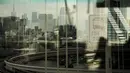 Cakrawala Tokyo terlihat melalui jendela bus dari Rainbow Bridge menjelang Olimpiade Tokyo 2020 pada 14 Juli 2021. Di bawah protokol yang ketat, satu-satunya cara untuk melihat sekilas ibu kota adalah dari kendaraan yang mengantar para tamu dari desa atlet atau hotel ke venue. (AP Photo/Jae CHong)