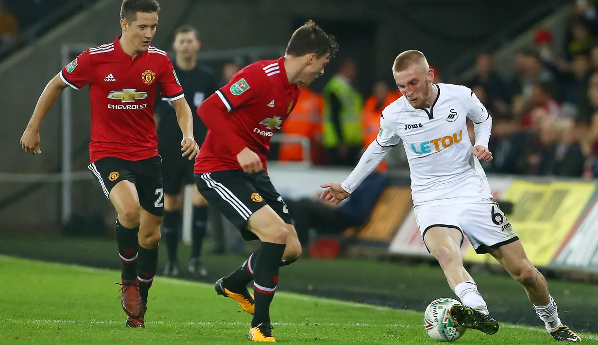 Striker Swansea City, Oli McBurnie, berusaha melewati pemain Manchester United pada laga Piala Liga Inggris di Stadion Liberty, Swansea, Selasa (24/10/2017). Manchester United menang 2-0 atas Swansea City. (AFP/Geoff Caddick)
