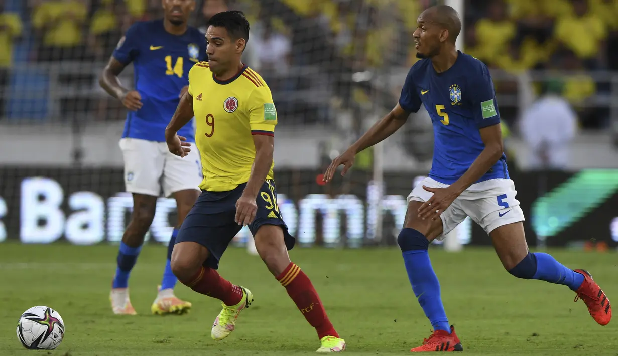 Penyerang Kolombia Radamel Falcao (kiri) berebut bola dengan gelandang Brasil Fabinho pada Kualifikasi Piala Dunia 2022 zona Amerika Selatan di Stadion Roberto Melendez, Senin (11/10/2021) dinihari WIB. Brasil ditahan imbang Kolombia 0-0. (JUAN BARRETO / AFP)
