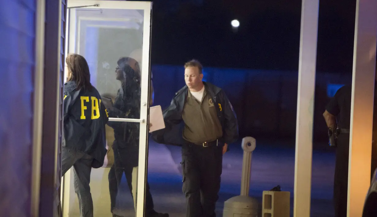 Anggota FBI tampak memasuki bangunan dekat bioskop tempat terjadinya penembakan di Lafayette, Louisiana, AS, Kamis (23/7/ 2015).  Diduga pria 58 tahun ini melepaskan tembakan yang menewaskan dua orang dan melukai tujuh orang lainnya. (REUTERS/Lee Celano)