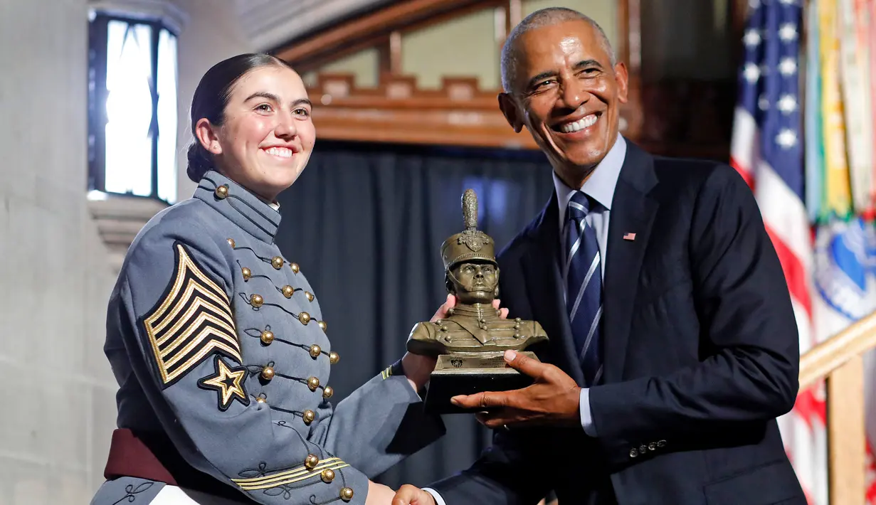 Mantan Presiden Amerika Serikat (AS), Barack Obama (kanan) menerima patung kadet dalam upacara penganugerahan Sylvanus Thayer Award 2024 dari Akademi Militer AS di West Point, New York, pada 19 September 2024. (KENA BETANCUR/AFP)