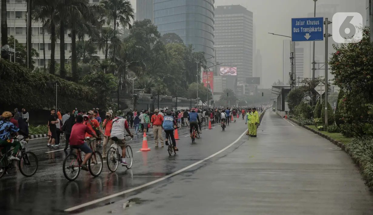 Suasana saat car free day (CFD) di kawasan Bundaran HI, Jakarta, Minggu (29/12/2019). Kendati tidak seramai saat cerah, warga yang berlari, jalan santai, atau swafoto masih menjadi pemandangan di area CFD usai hujan mengguyur Jakarta. (Liputan6.com/Faizal Fanani)