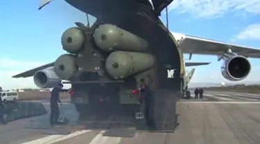 Sebuah potongan rekaman video dari Departemen Pertahanan Rusia pada (26/11). Sistem rudal pertahanan udara S-400 Rusia dikeluarkan dari pesawat cargo saat tiba di pangkalan udara Hmeymim di Suriah. (Reuters/ Departemen Pertahanan Federasi Rusia)