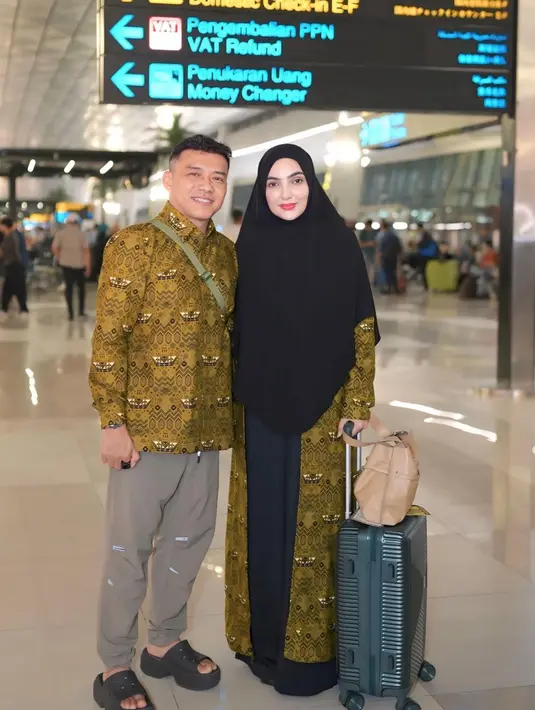 Anang dan Ashanty resmi bertolak ke Tanah Suci untuk menunaikan ibadah haji melalui Bandara Soekarno-Hatta, Tangerang. Ashanty pun mengenakan kerudung panjang hitam dengan outer seragam motif batik. [@ashanty_ash]