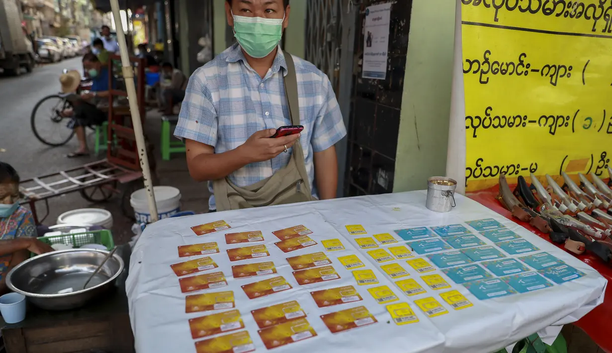 Seorang pedagang kaki lima memamerkan kartu SIM seluler di Yangon, Myanmar (4/2/2021).  Pemerintah militer baru Myanmar telah memblokir akses ke Facebook karena perlawanan terhadap kudeta yang melonjak di tengah seruan pembangkangan sipil. (AP Photo)