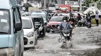 Sejumlah kendaraan terjebak kemacetan akibat banjir yang menggenangi Jalan Jatinegara Barat, Jakarta, Senin (8/2/2021). Banjir yang menggenangi Jalan Jatinegara Barat terjadi akibat luapan Kali Ciliwung yang dipicu hujan deras di Jakarta dan Bogor sejak dini hari tadi. (merdeka.com/Iqbal S. Nugroho)