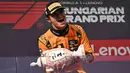 Pembalap McLaren, Lando Norris mengangkat trofi saat merayakan kemenangan dalam ajang balap Formula 1 GP Hungaria 2025 di sirkuit Hongaroring, Minggu (03/08/2025) waktu setempat. (AP Photo/Denes Erdos)