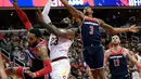 Pebasket Cleveland Cavaliers, LeBron James dan pebasket Washington Wizards, Bradley Beal berebut bola pada lanjutan NBA di Verizon Center, Minggu (17/12). James menyampaikan protes terhadap Presiden Donald Trump lewat sepatu beda warnanya. (AP/Nick Wass)