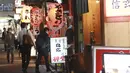 Orang-orang memasuki sebuah restoran di Tokyo, Jepang, Senin (25/10/2021). Pemerintah Metropolitan Tokyo mencabut seluruh pembatasan di tempat-tempat makan menyusul penurunan jumlah kasus corona COVID-19 harian di negara itu. (AP Photo/Koji Sasahara)