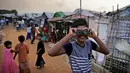 Seorang bocah Rohingya melihat melalui teropong mainan pada perayaan Idul Adha di kamp pengungsi Kutupalong, Bangladesh, Rabu (22/8). Hampir setahun mereka menghuni kamp ini usai kabur menghindari represi militer di Negara Bagian Rakhine. (AP/Altaf Qadri)