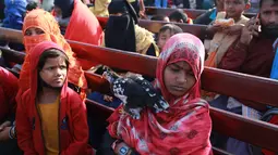 Pengungsi Rohingya duduk di kapal Angkatan Laut Bangladesh saat mereka dipindahkan ke pulau rawan banjir yang kontroversial, Bhashan Char di Teluk Benggala, di Chittagong (29/12/2020). Pada gelombang pertama lebih dari 1.600 pengungsi direlokasi. (AFP/Rehman Asad)