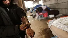 Seorang pria menggunakan heroin di bawah jembatan yang menjadi pusat penggunaan heroin di Kensington, Philadelphia (24/1). Menurut DAE Amerika Serikat, penggunaan heroin telah berlipat ganda di seluruh negeri sejak 2010. (Spencer Platt/Getty Images/AFP)