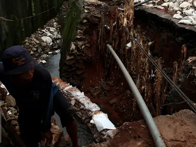 Petugas meninjau tanah longsor di kawasan Kuningan, Setiabudi, Jakarta, Senin (21/11). Longsor ini terjadi karena curah hujan yang meningkat dan kondisi turap yang tidak bisa lagi menahan air. (Liputan6.com/Johan Tallo)