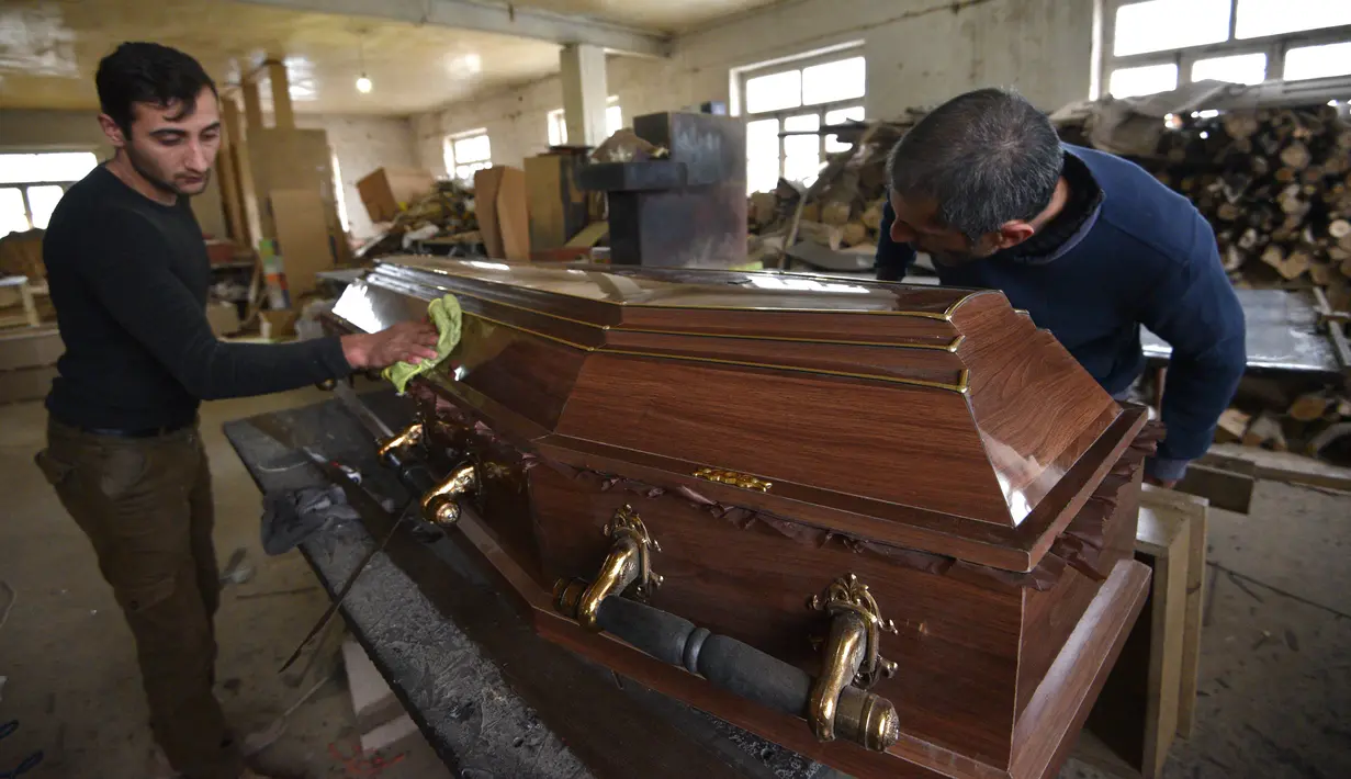 Pekerja membuat peti mati di bengkel furnitur, yang secara total mengalihkan bisnisnya ke produksi peti mati di tengah konflik militer Armenia dan Azerbaijan atas wilayah Nagorno-Karabakh yang memisahkan diri, di ibu kota provinsi yang disengketakan, Stepanakert (4/11/2020). (AFP/Karen Minasyan)