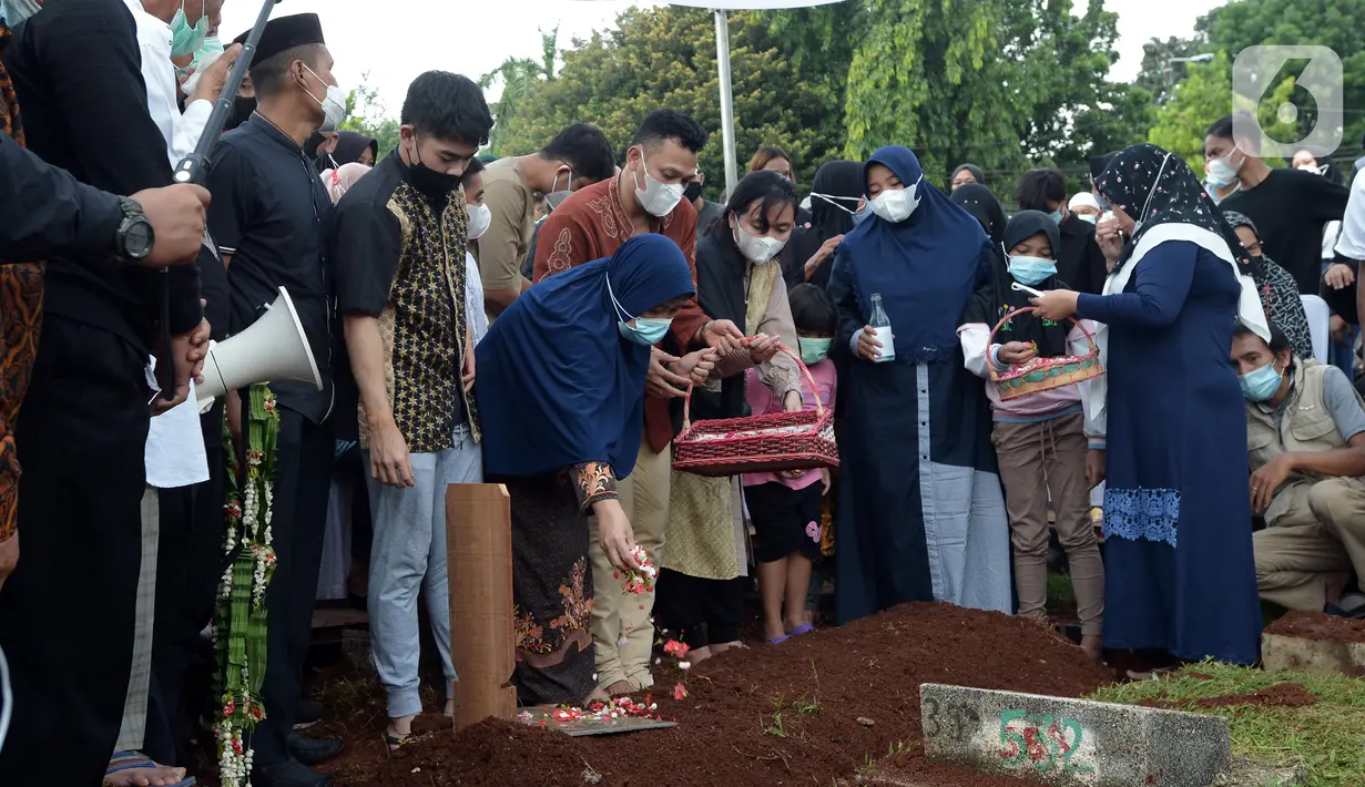Keluarga dan kerabat menaburkan bunga di atas makam mantan pebuku tangkis Indonesia Markis Kido saat pemakaman di TPU Kebon Nanas, Jakarta, Selasa (15/6/2021). Peraih mendali emas Olimpiade Beijing 2008 tersebut meniggal di Tangerang pada 14 Juni 2021 malam. (merdeka.com/Imam Buhori)
