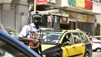 Bendera nasional Senegal tergantung dari balkon di jalan sibuk Dakar (4/2/2022). Senegal akan bertanding melawan Mesir pada babak final Piala Afrika 2021 di Paul Biya stadium, Senin (7/2/2022) dini hari WIB besok. (AFP/Seyllou)