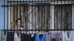 Seorang wanita menyaksikan pemutaran film bertema kekerasan aparat, dalam sebuah festival 'outdoor' di Bucharest, Rumania (31/8/2021). International Roma Theatre Festival digelar di permukiman warga ekonomi rendah. (AP Photo/ Vadim Ghirda)