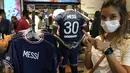 Suporter Paris Saint-Germain memberi isyarat dengan jersey bertuliskan nama Lionel Messi di toko resmi PSG, di Paris, Rabu (11/8/2021). Penjualan jersey PSG dengan nama Messi dan nomor punggung 30 laris manis, bahkan rela antre panjang. (AP Photo/Francois Mori)