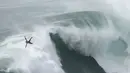 Peselancar Eric Rebiere dari Prancis mengudara keluar dari ombak selama kompetisi selancar ombak besar Nazare Tow Challenge di Praia do Norte, atau Pantai Utara, di Nazare, Portugal, 10 Februari 2022. (AP Photo/Armando Franca)