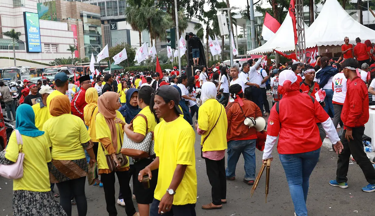 Massa pendukung pasangan calon presiden dan wakil presiden nomor urut 01 Jokowi-Ma'ruf Amin saat berkumpul di sekitar Bundaran HI, Jakarta, Sabtu (13/4). Ribuan orang berkumpul untuk menghadiri kampanye akbar pasangan Jokowi-Ma'ruf Amin di Stadion GBK. (Liputan6.com/Immanuel Antonius)