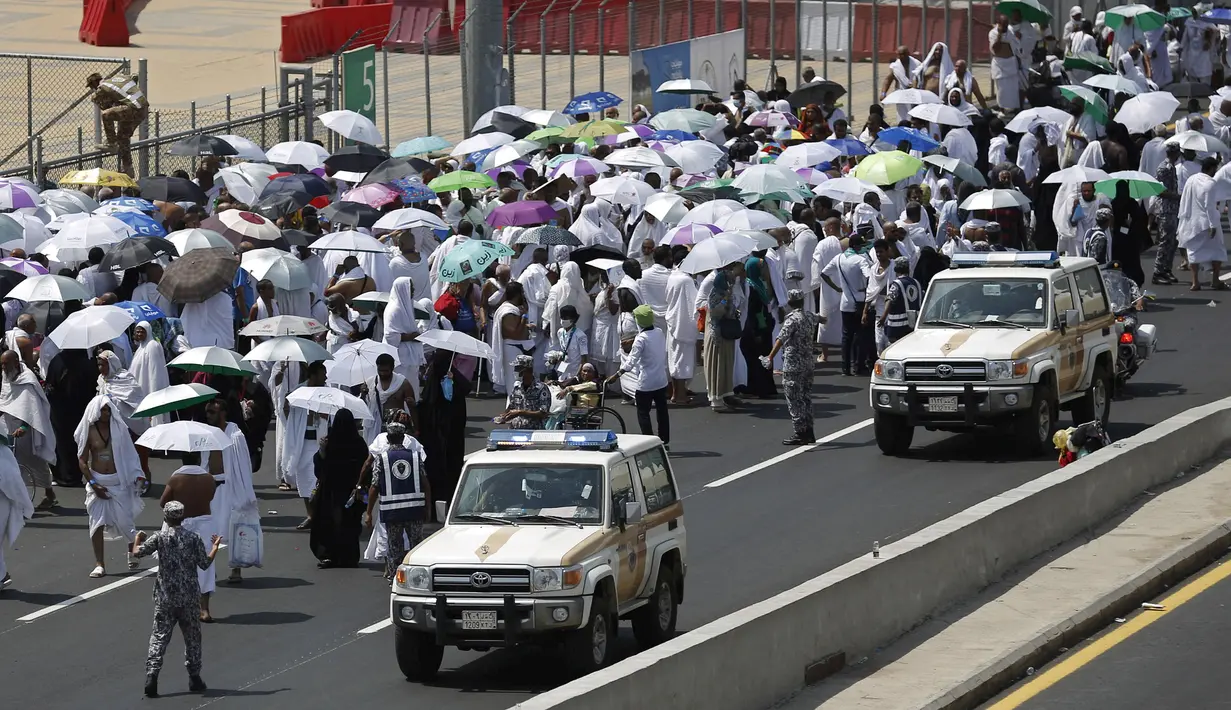 Kendaraan polisi melintas dekati ribuan umat muslim di salah satu jalan di Mina, Arab Saudi, Kamis (24/9/2015). Sekitar 310 jemaah wafat akibat berdesak-desakan saat prosesi lempar jumrah di Mina. (REUTERS/Ahmad Masood)