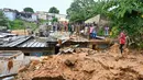 Warga melihat tempat di mana tim penyelamat mencari korban setelah rumah runtuh setelah hujan lebat di distrik Attecoube di Abidja, Pantai Gading (16/6/2022). Enam orang tewas semalam setelah hujan lebat memicu tanah longsor di ibu kota ekonomi Pantai Gading Abidjan, kata layanan darurat. (AFP/Issouf Sanogo)