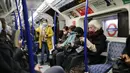 Penumpang melakukan perjalanan dengan kereta bawah tanah Transport for London (TfL) Victoria Line menuju pusat kota London (5/1/2022). Kasus Covid-19 harian negara itu menembus 200.000 untuk pertama kalinya. (AFP/Tolga Akmen)