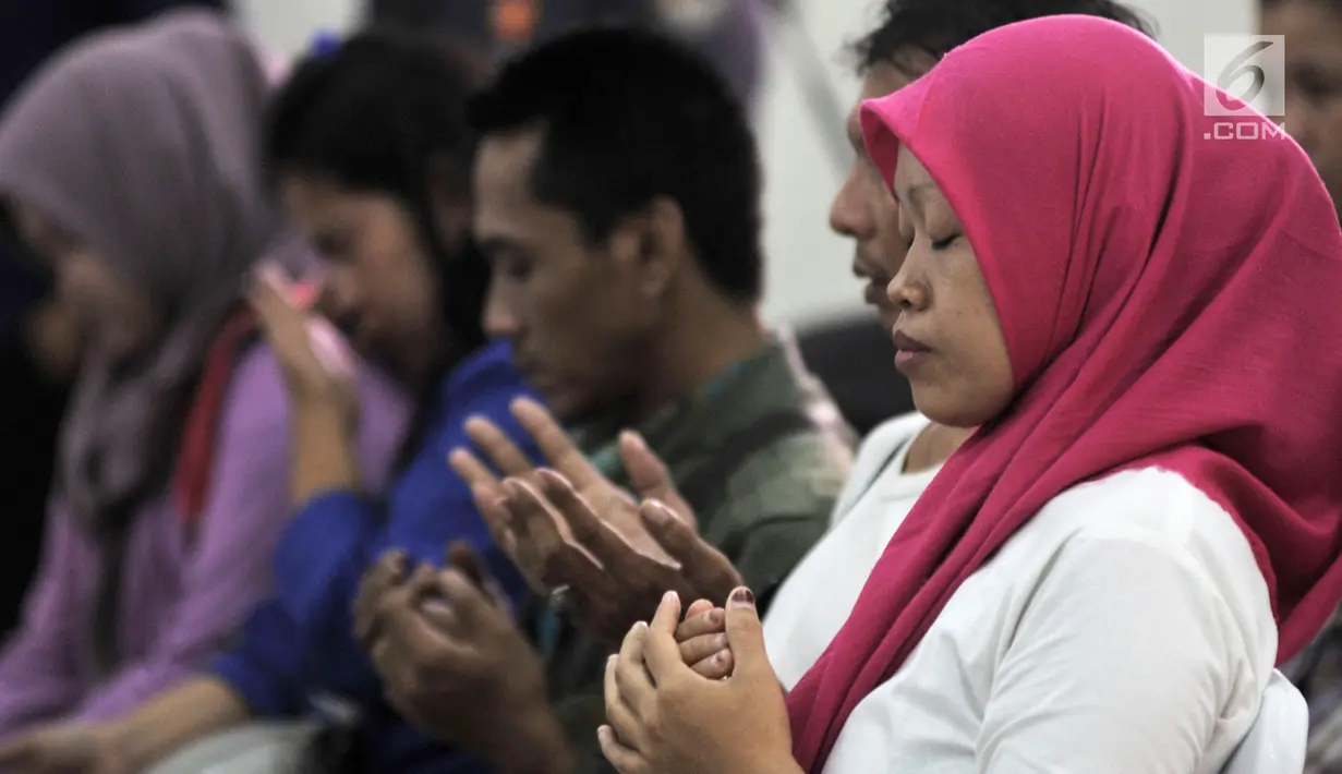 Istri almarhum Ketua KPPS Bekasi Masnun memanjatkan doa saat acara Ngopi Bareng Ombudsman di Ruang Serbaguna Ombudsman RI, Jakarta, Selasa (30/4/2019). (merdeka.com/Iqbal Nugroho)