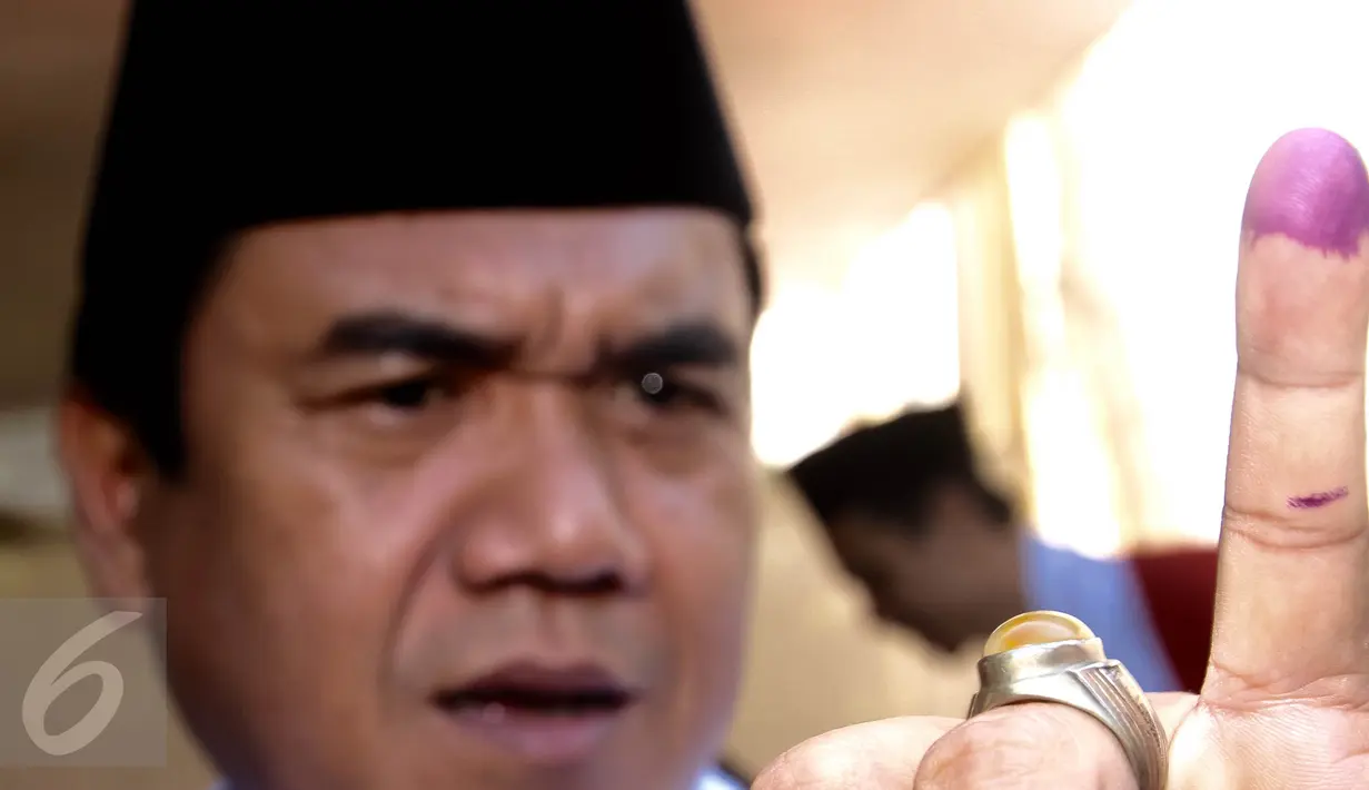 Calon Walikota Tangerang Selatan nomor urut 2, Arsid menunjukkan jari kelingking usai mencoblos di TPS 31, Kelurahan Pondok Benda, Tangerang Selatan. (Rabu (9/12). Arsid merupakan pemilih perdana pada TPS tersebut. (Liputan6.com/Fery Pradolo)