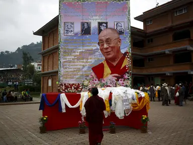 Seorang biksu Tibet berdoa di depan potret Dalai Lama saat perayaan ulang tahun ke-80 di Kathmandu, Nepal (6/7/2015). Dalai lama merupakan nama gelar dari agama Budha, gelar  ini diturunkan secara turun temurun. (REUTERS/Navesh Chitrakar)