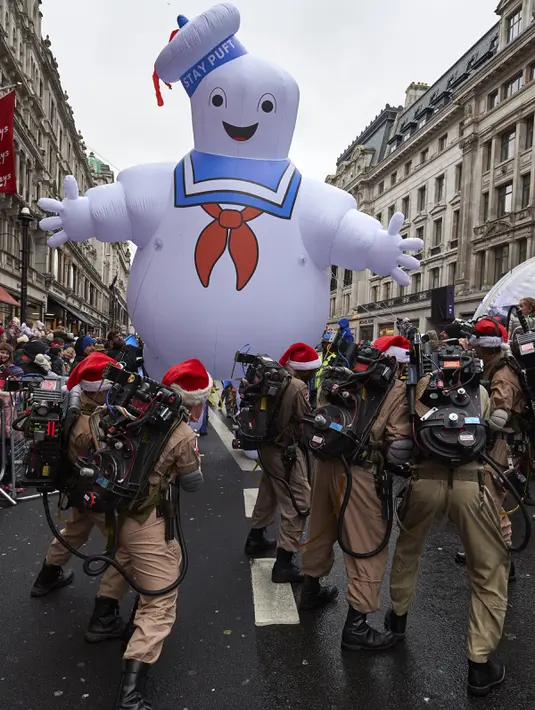 Peserta mengenakan kostum tokoh film Ghostbusters lengkap dengan balon udara besar ikut memeriahkan acara Hamleys Natal Toy Parade di Regent Street di London, Inggris (20/11). (AFP/Niklas Halle'n)