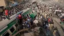 Petugas dibantu warga mengevakuasi korban kecelakaan kereta di Karachi, Pakistan, Kamis (3/11). Kecelakaan itu terjadi akibat kereta penumpang Farid Express bertabrakan dengan kereta penumpang Zakria Express. (AP Photo/Shakil Adil)