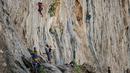 Peserta berusaha memanjat tebing dalam Festival Mendaki tahunan 2019 di pulau Kalymnos, Yunani (4/10/2019). Pemandangan menakjubkan dan cuaca bagus menjadikan pulau ini sebagai tujuan utama bagi pemanjat dari semua tingkatan dengan lebih dari 2500 rute pendakian. (AFP Photo/Aris Messinis)