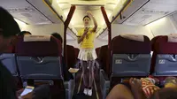 Salah satu pramugari yang mengenakan kostum Timnas Brasil sedang mempraktikan cara menggunakan alat pengaman kepada penumpang dalam penerbangan Kunming ke Hangzhou, Yunnan, China, Senin (23/6/14). (REUTERS/Wong Campion)