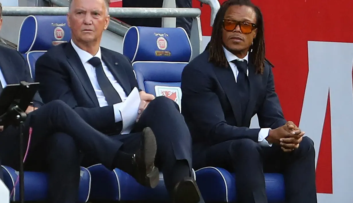 Pelatih Belanda Louis van Gaal (kiri) dan asistennya Edgar Davids menyaksikan pemainnya bertanding melawan Wales selama pertandingan grup A4 UEFA Nations League di stadion Cardiff City di Cardiff, Wales selatan, Kamis (9/6/2022). Belanda menang tipis atas Wales 2-1. (AFP/Geoff Caddick)