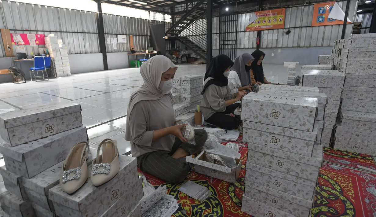 Pekerja melakukan pengepakan produk tas dan sepatu sandal yang akan dikirim ke pelanggan melalui marketplace di bengkel kerja Patris di kawasan Katulampa, Bogor, Jawa Barat, Senin (14/4/2025). (merdeka.com/Arie Basuki)