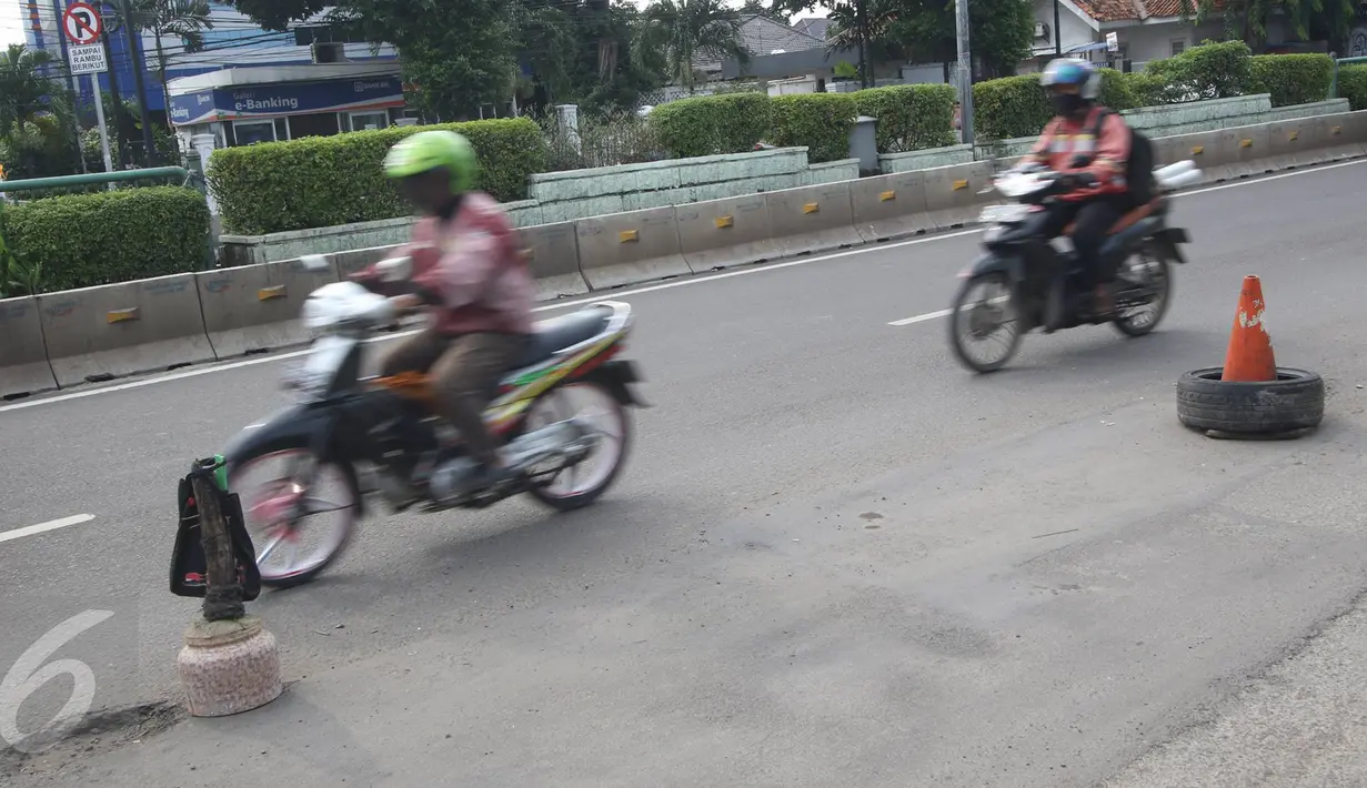 Kendaraan melintasi jalanan yang berlubang di Jalan Otista Raya, Jakarta, Rabu (22/2). Kondisi tersebut berbahaya bagi pengguna jalan, khususnya pengendara sepeda motor yang melintas saat malam hari. (Liputan6.com/Immanuel Antonius)