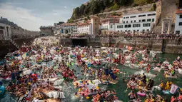 Ribuan orang berdatangan mendayung perahu rakitan buatan mereka di pelabuhan kota Basque San Sebastian utara selama (12/8).  Acara ini menghadirkan Pesta, Konser, Acara berperahu bertema bajak laut Dan kembang api malam. (AFP Photo/Gari Garaialde)