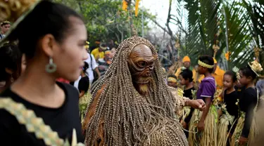 Seorang anggota dari adat Mah Meri mengenakan kostum dan topeng saat ritual Puja Pantai di Pulau Carey, Malaysia (2/1). Mereka adalah orang asli yang mendiami Pulau Carey dan merupakan salah satu etnik Malaysia yang masih ada. (AFP/Manan Vatsyayana)