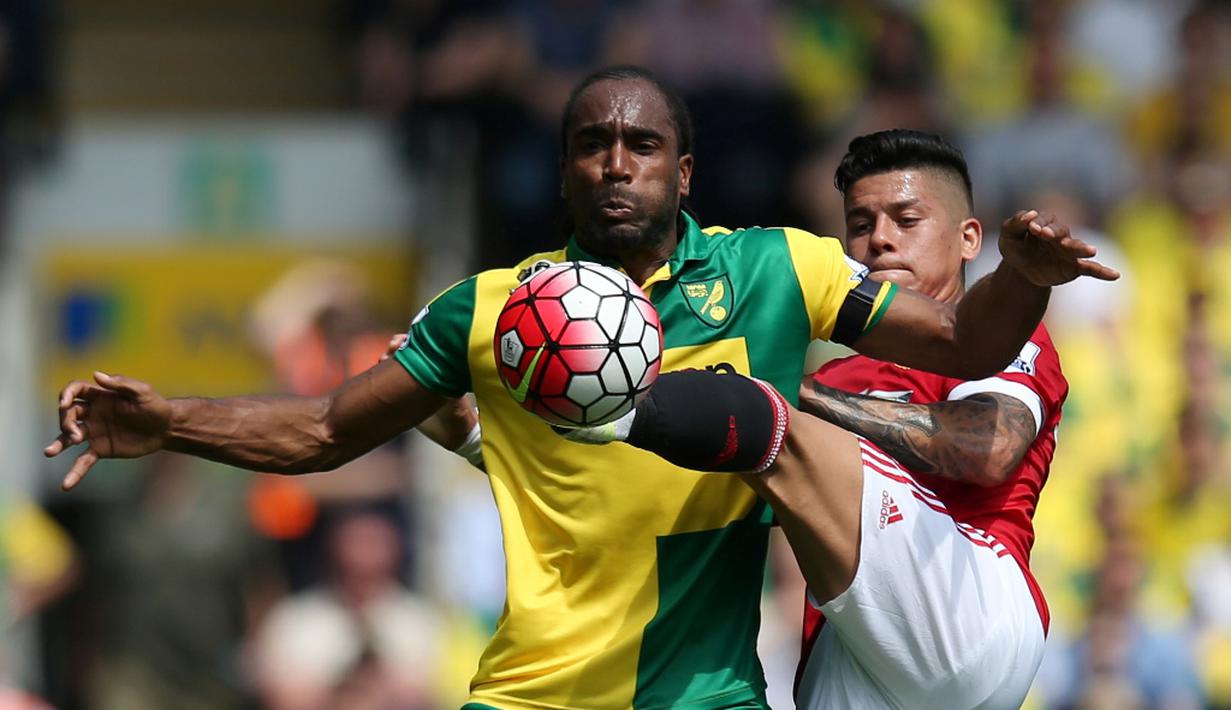 Pemain MU, Marcos Rojo (kanan), berebut bola dengan pemain Norwich City, Sebastien Bassong, dalam lanjutan Premier League, di Stadion Carrow Road, Norwich, Sabtu (7/5/2016). (Action Images via Reuters/Paul Childs)