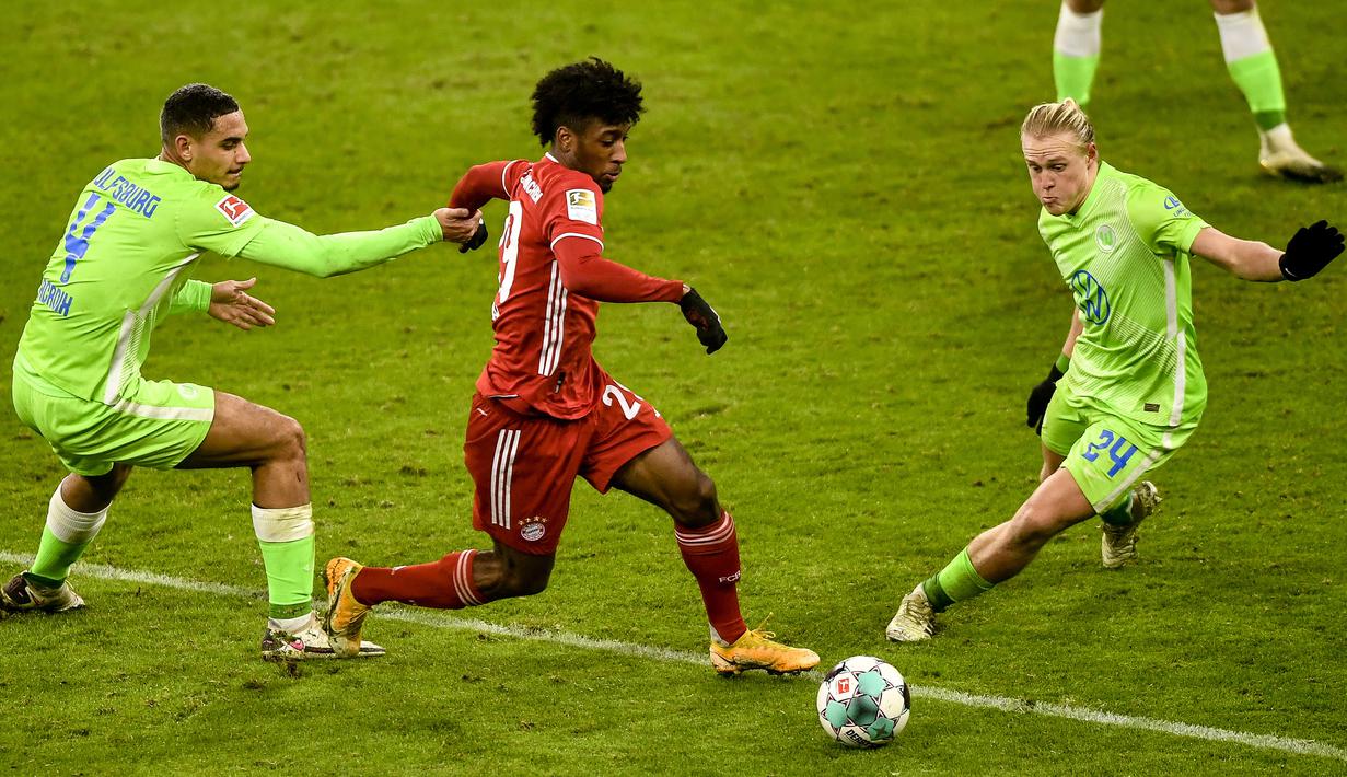 Penyerang Bayern Munchen, Kingsley Coman, berebut bola dengan bek Wolfsburg, Maxence Lacroix, pada laga lanjutan Liga Jerman di Allianz Arena, Kamis (17/12/2020) dini hari WIB. Bayern Munchen menang 2-1 atas Wolfsburg. (AFP/Lukas Barth-Tuttas/pool)
