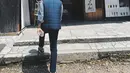 Walaupun dipotret dari belakang, terlihat Jesse Choi kembali memilih tampilan kasual yang chic. Kemeja denim dilapisi dengan puffer vest biru navy dan dipadu dengan celana panjang hitam. Foto: Instagram.